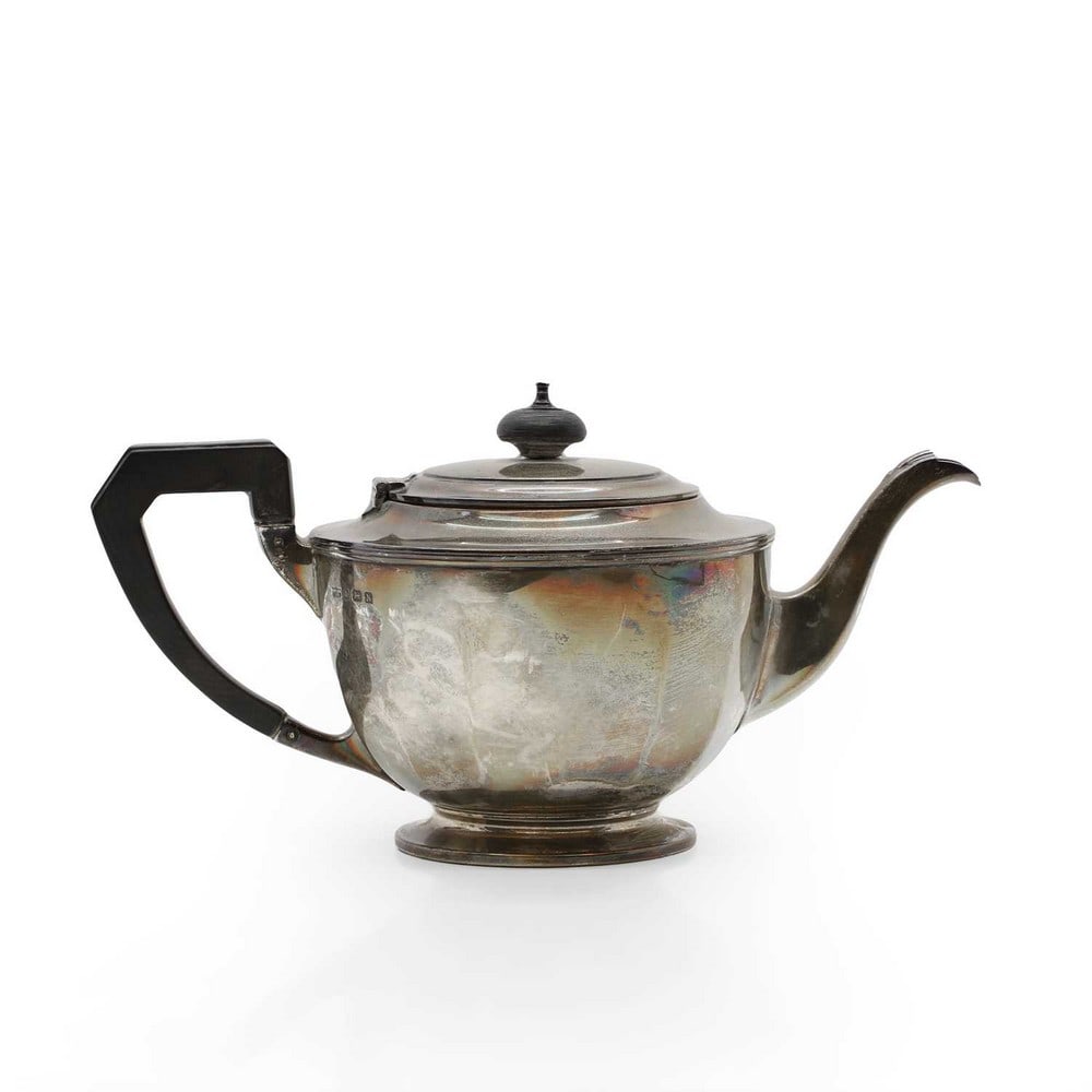 A silver teapot,: A silver teapot, by Mappin & Webb, Birmingham 1937, of faceted form with an ebonised handle and finial, 25.5cm wide 14.2ozt Condition Report: Minor knocks and wear. Overall, good order.