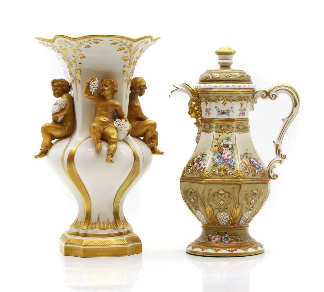 A Capodimonte coffee pot: A Capodimonte coffee pot the blush ivory glaze with rose head decorated panels, fitted mask head decorated spout, 32cm high, and a similar cupid decorated vase, 33cm high (2) Provenance: The property