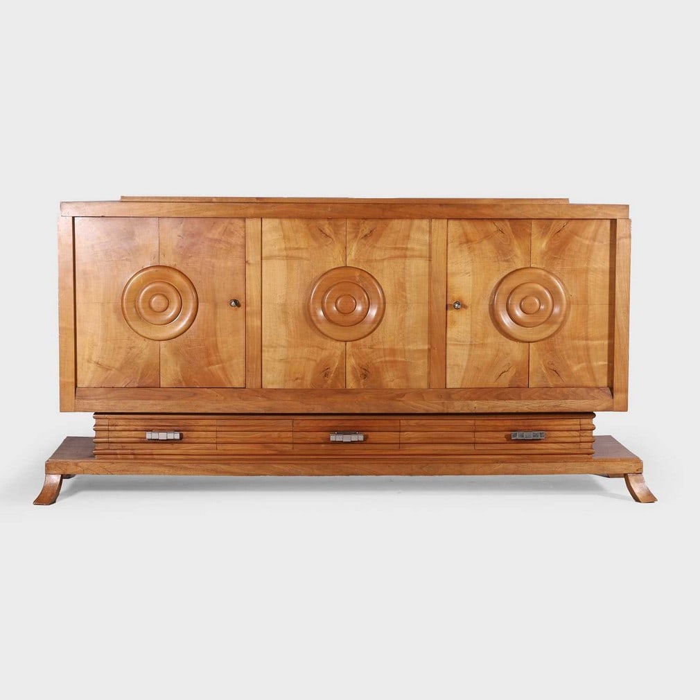 Manner of Charles Dudouyt,: Manner of Charles Dudouyt, an oak sideboard, early 20th century, with two side cupboards, each with carved circle detail, opening to reveal two shelved sections, over three drawers with stepped metal