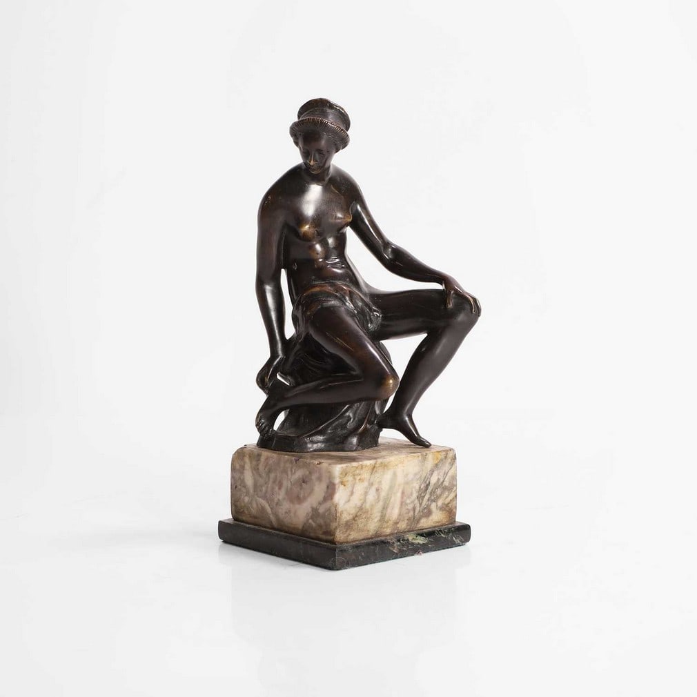 After Barthélemy Prieur,: After Barthélemy Prieur, a bronze figure of a woman pulling a thorn from her heel, 19th century, French, raised on a marble plinth base, 7cm wide 7.5cm deep 8cm high Condition Report: Deep patina