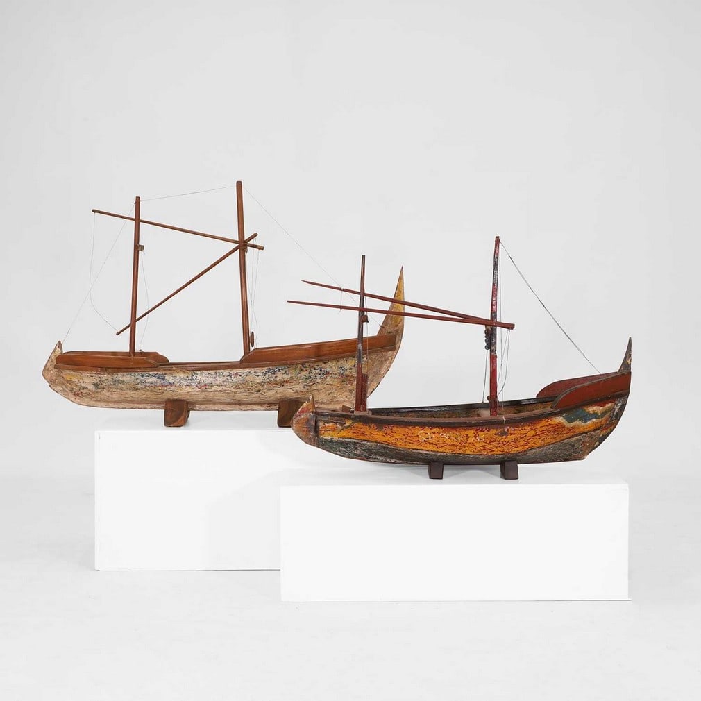 Two painted hardwood models of boats,: Two painted hardwood models of boats, Balinese, each with a distressed painted wooden hull, tapering mast and string rigging, largest 113cm wide 36cm deep 77cm high (2) Condition Report: deliberate di