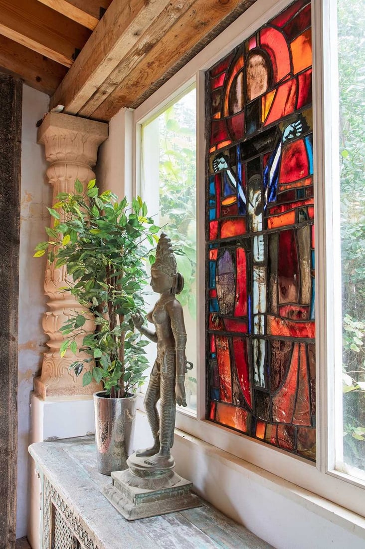 A large stained-glass panel in the manner of John Piper and Patrick Reyntiens,: A large stained-glass panel in the manner of John Piper and Patrick Reyntiens, mid-20th century, depicting Christ crucified on a panelled red ground, 155 x 65cm