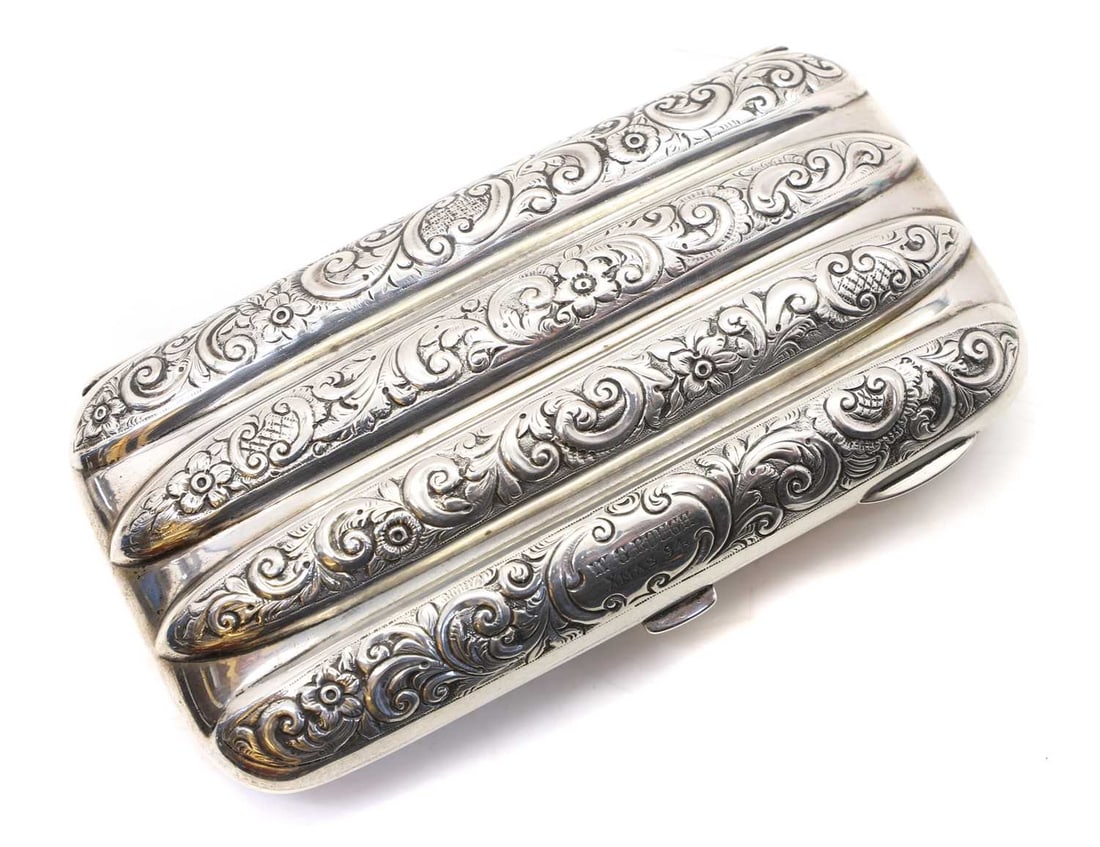 A Victorian silver pocket cigar case,: A Victorian silver pocket cigar case, Birmingham 1894, makers mark for John Cole, repousee decorated case, gilded interior, inscribed 'Xmas '94' 13.25cm wide 6.75cm deep 3cm high 4.9ozt Condition Repo