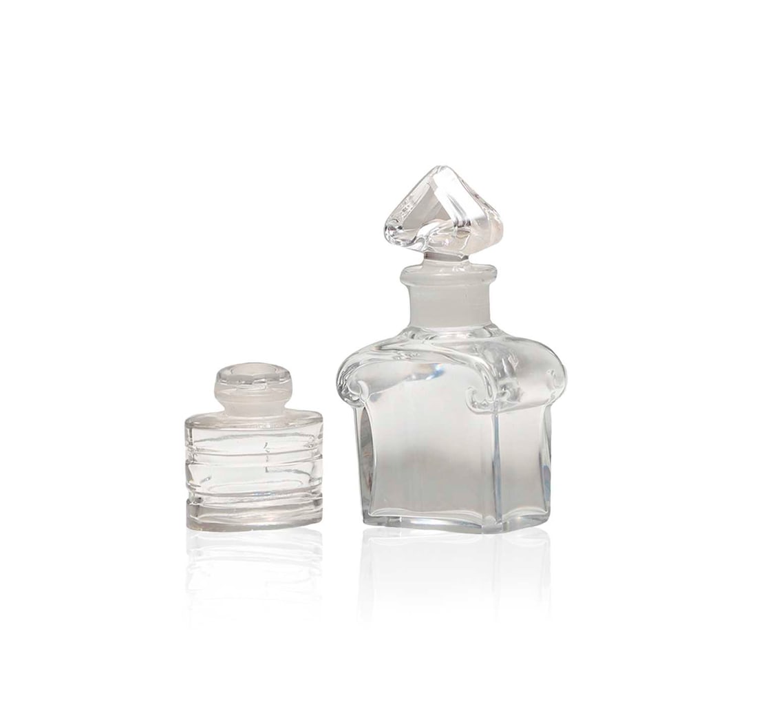Two Baccarat glass scent bottles,: Two Baccarat glass scent bottles, comprising a clear scent bottle, with a faceted stopper, 5.3cm high, and a Guerlain scent bottle, 12cm high, acid etched marks (2) Condition Report: Guerlain) Small n