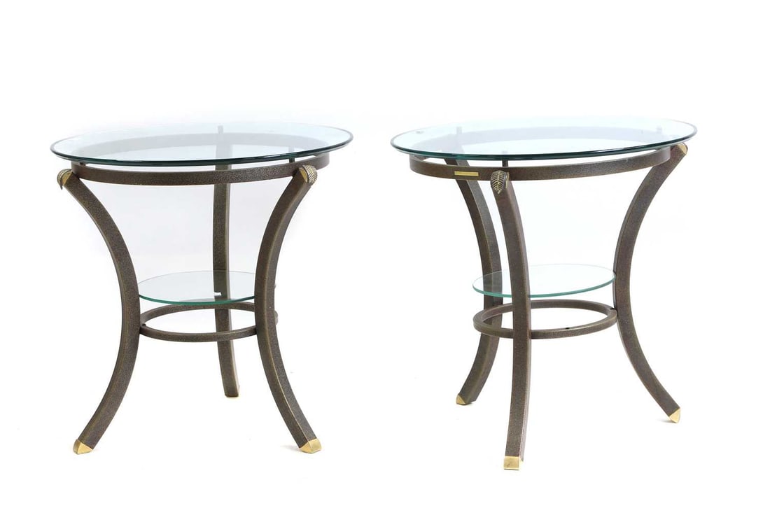 A pair of Pierre Vandel lamp tables: A pair of Pierre Vandel lamp tables late 20th century the circular glass tops on swept gilt metal bases with glass undertier 60cm diameter 60cm high (2)
