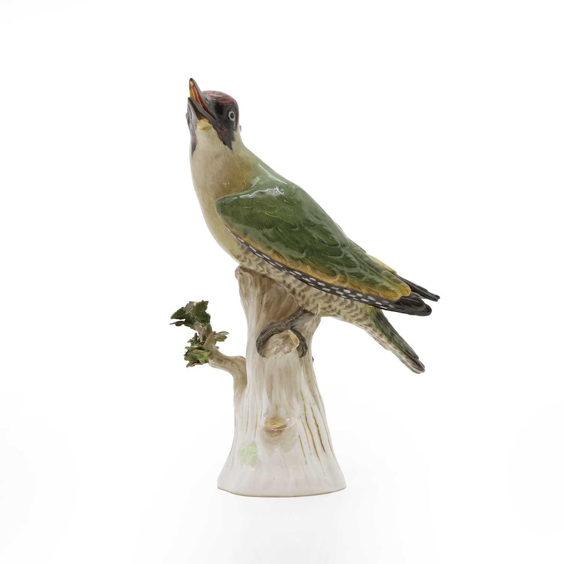 A Meissen porcelain model of a green woodpecker,: A Meissen porcelain model of a green woodpecker, 19th century, German, painted in enamel colours and gilt, with black open beak, red cap, green body, perched on a branched stump, with blue underglaze 