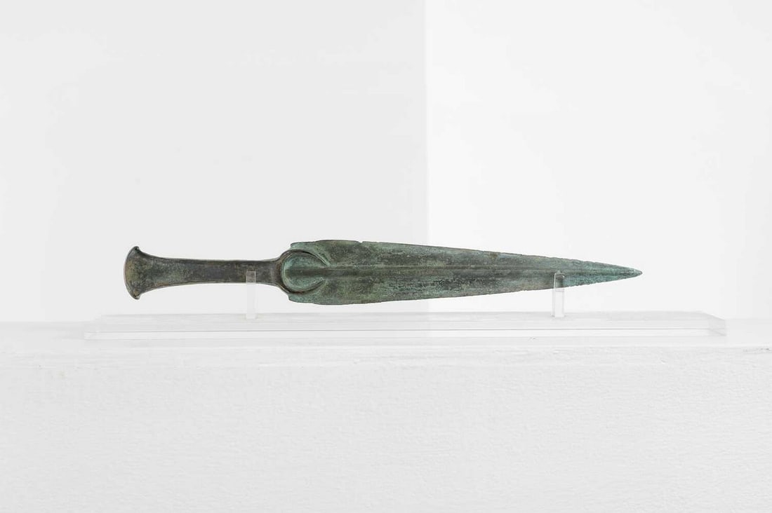 A Luristan bronze dagger,: A Luristan bronze dagger, c.1800 BCE-600 BCE, the pointed blade with raised mid-rib and a flanged hilt, 4.5cm wide 33.5cm long Provenance: A private collection, UK; acquired on the London art market c
