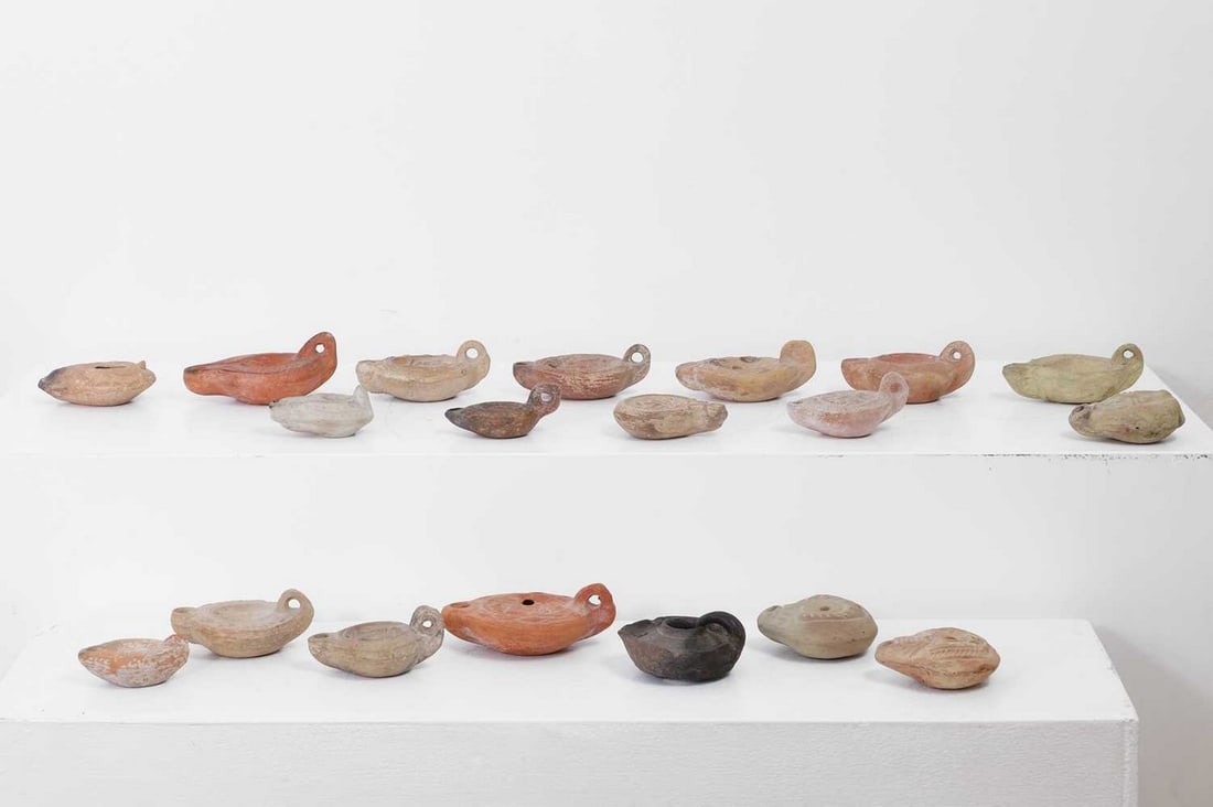 A group of Roman terracotta oil lamps,: A group of Roman terracotta oil lamps, comprising variously sized examples, some with erotic decoration, largest 9.5cm wide 12.5cm deep 5cm high (19) Provenance: From the collection of David King (194
