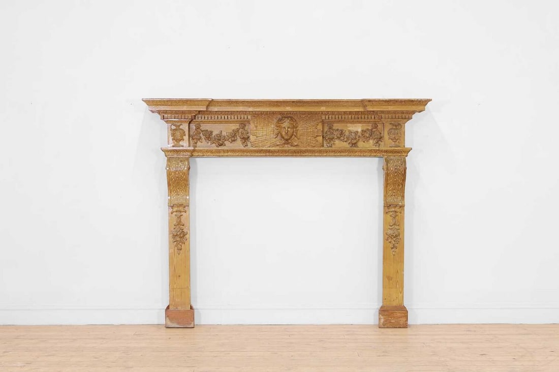 A George II-style painted pine chimney piece in the manner of William Kent,: A George II-style painted pine chimney piece in the manner of William Kent, 19th century and later, with a breakfront mantelpiece above a foliate frieze centred with the head of Apollo, above scrollin