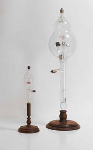 Two rock mineral Geissler tubes,: Two rock mineral Geissler tubes, c.1890, comprising a large tube with five rock sample pedestals, each with glass leg clamps, a central supporting stem from the base globe, 56cm high, and a smaller ex