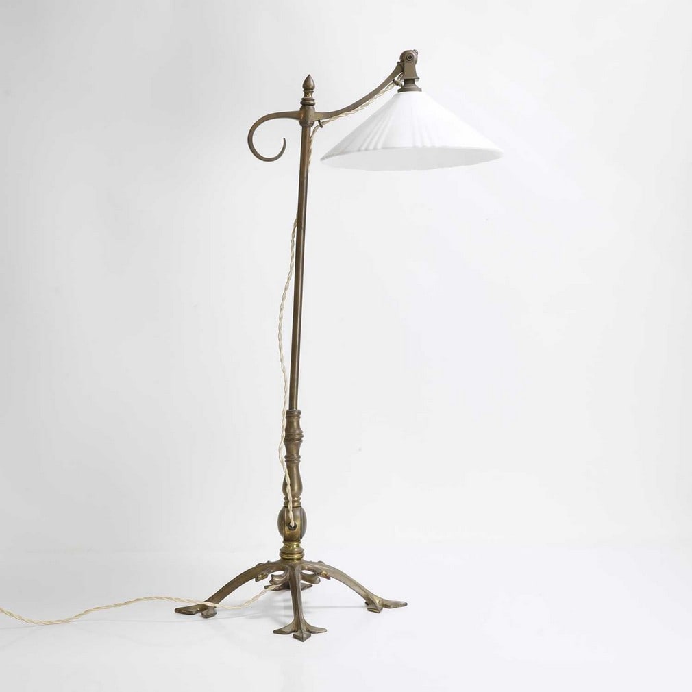 Manner of WAS Benson,: Manner of WAS Benson, an Arts and Crafts reading light, brass with a ceramic glass shade on a hinged mount, 32cm wide 22cm deep 67cm high