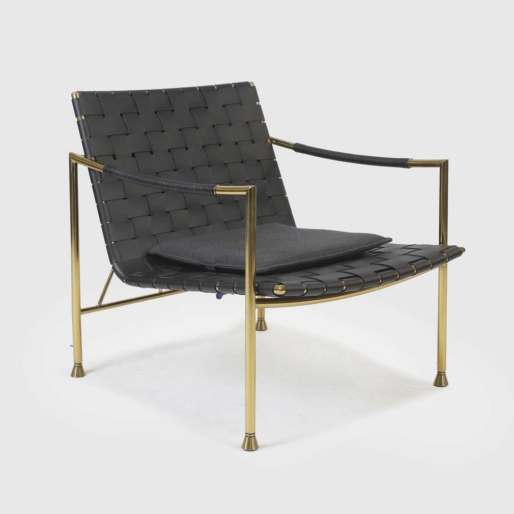 Jonathan Adler (American, b.1966),: Jonathan Adler (American, b.1966), a 'Thebes' lounge chair, the woven leather seat supported on a polished brass frame, with a charcoal grey upholstered seat pad, 67cm wide 83cm deep 75cm high, 45cm h