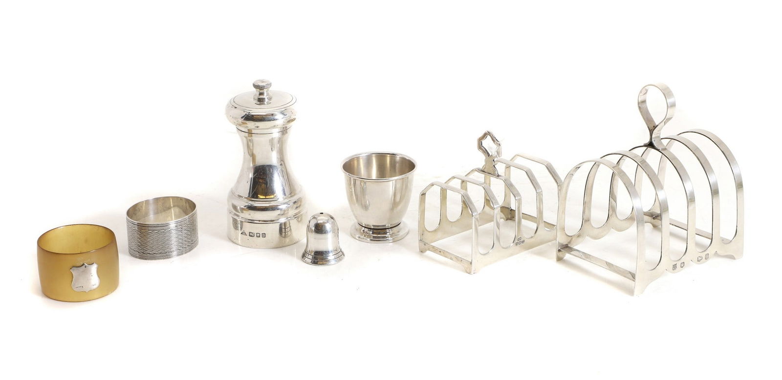 A silver pepper grinder,: A silver pepper grinder, by J A Campbell, Birmingham 1987, of typical form, 10cm high, together with two silver four divisioned toast racks, largest 10.8cm high, a pill box, 3cm high, an egg cup, 4.5c