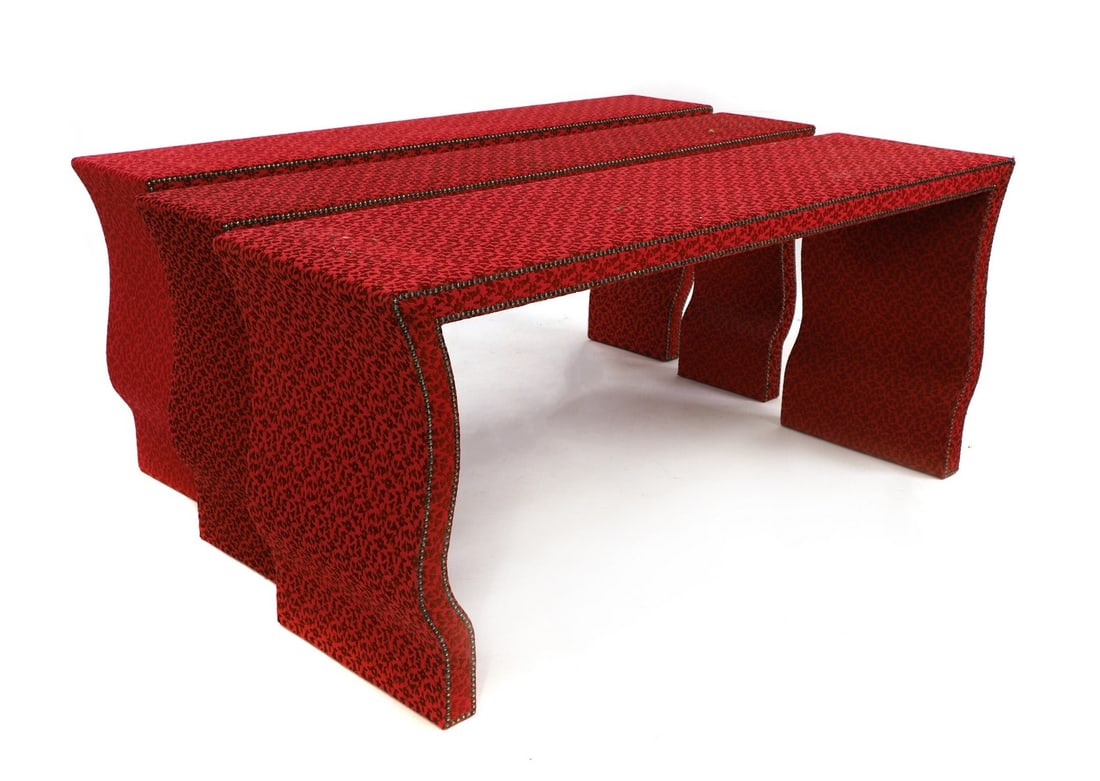 A pair of fabric covered console tables,: A pair of fabric covered console tables, of recent manufacture, in the Chinese manner, each rectangular top with pointed shoulders and raised on shaped serpentine ends, with brass studded pink damask-