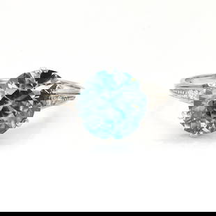 An Art Deco blue zircon and diamond ring,: An Art Deco blue zircon and diamond ring, the round mixed cut blue zircon, claw set to an engraved gallery, between diamond set elevated shoulders, into a plain hoop. In unmarked white metal, zircon e