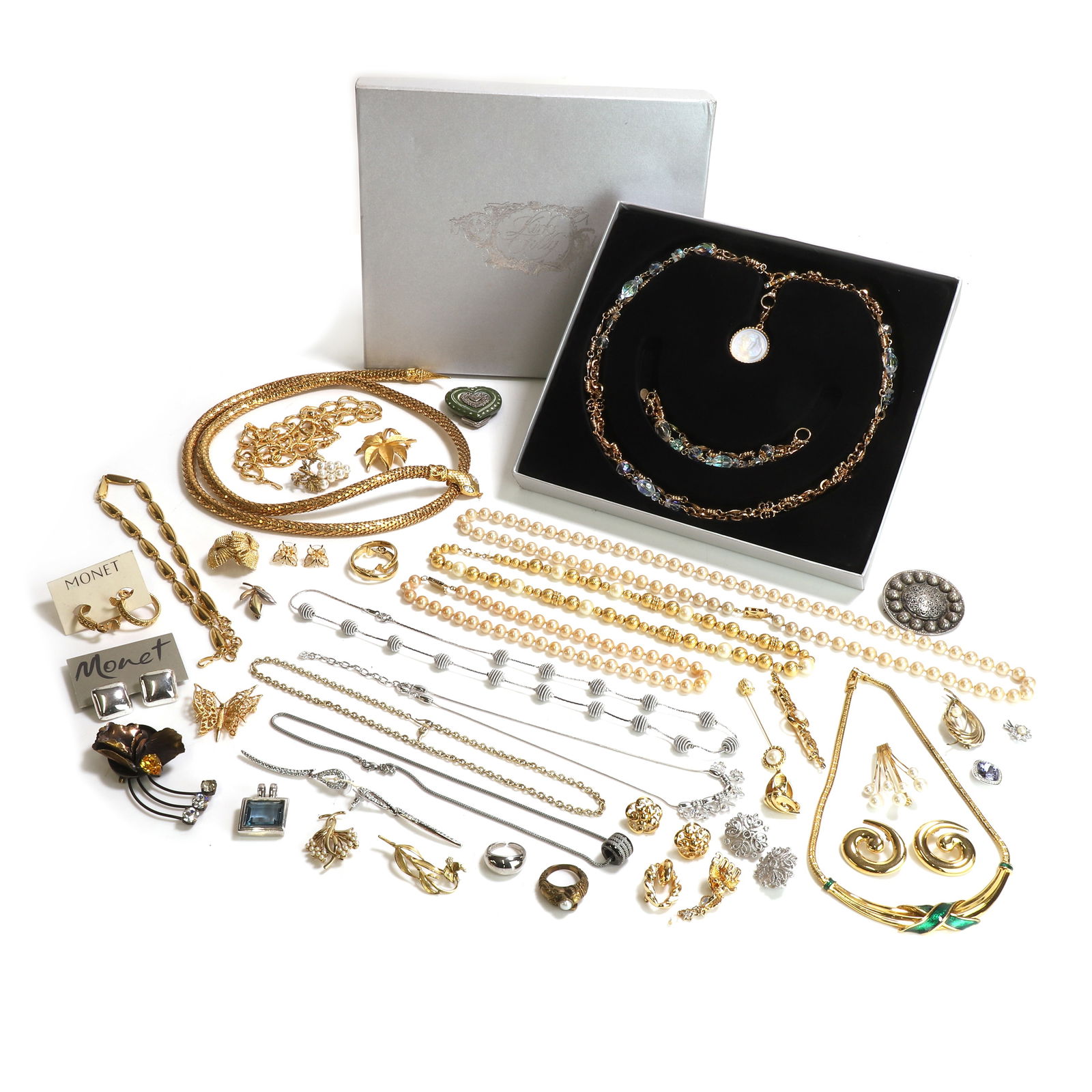 A collection of mostly signed costume jewellery,: A collection of mostly signed costume jewellery, to include a gilt metal paste snake wrap necklace, a pair of gilt metal hoop clip earrings, by Monet, a gilt metal foliate brooch, by Trifari, a pair o