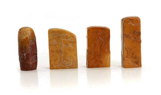 A group of four Chinese soapstone seals,: A group of four Chinese soapstone seals, 20th century, of various form, carved in a honey-coloured stone with literati in landscape scenes, 5.5 to 7cm high (4) Provenance: From the collection of the l