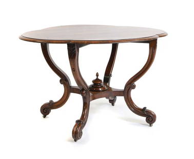 A Victorian rosewood centre table,: A Victorian rosewood centre table, late 19th century, with a shaped oval top, carved scrolled supports, united with an under tier, with a turned finial, 117.5cm wide 88.5cm deep 71.5cm high Condition