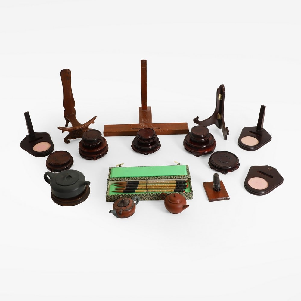 A collection of Chinese hardwood stands,: A collection of Chinese hardwood stands, having carved detailing, together with three redware teapots, the largest 15cm wide, and a boxed set of caligraphy brushes (qty.) Condition Report: Surface scr
