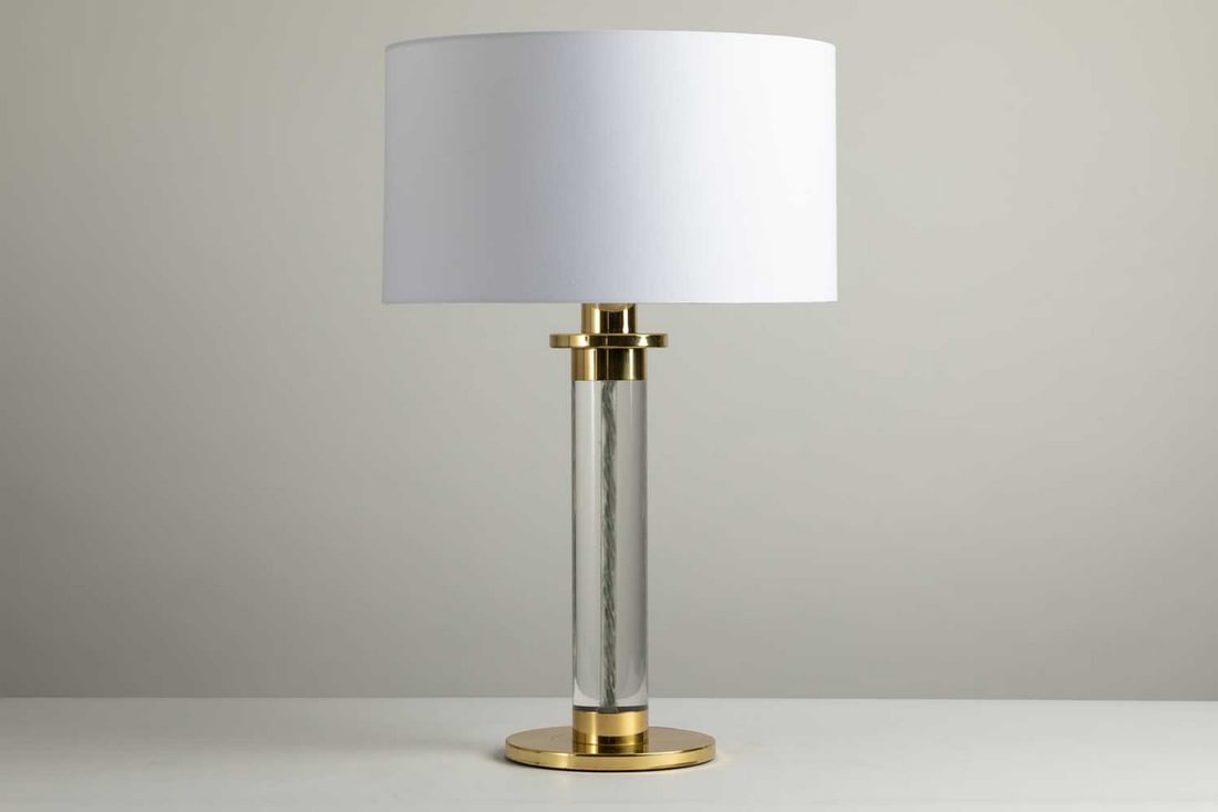 A Lucite and brass-mounted table lamp,: A Lucite and brass-mounted table lamp, 1970s, designed by Frederick Cooper of Chicago, with a cylindrical column, 21cm diameter plinth, 52cm high to top of the light fitting Condition Report: with sha