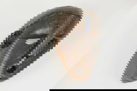 A carved mask,: A carved mask, Democratic Republic of Congo, Boa people, 25cm wide 17cm deep 33cm high Condition Report: Signs of old woodworm, one tooth lacking. Knocks, chips and scuffs present. Repair present to t