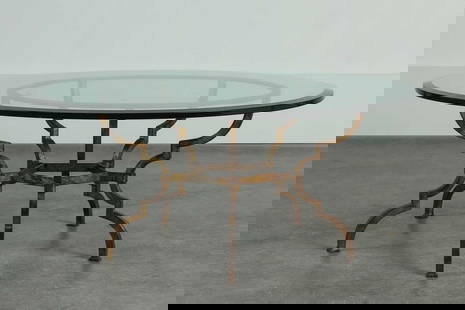 A circular coﬀee table,: A circular co&#64256;ee table, of recent manufacture, with a circular glass top, raised on a gilded wrought-iron stand, 106.5cm diameter 46cm high