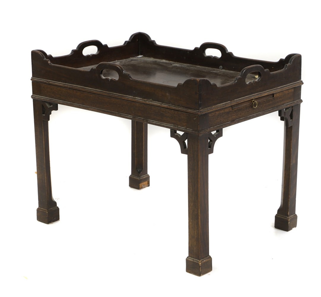 A mahogany tray top table,: A mahogany tray top table, in the Georgian style, with a shaped gallery, two candle slides, with brass handles, 65cm wide 48cm deep 54cm high Condition Report: Some losses and knocks, Used. With loss