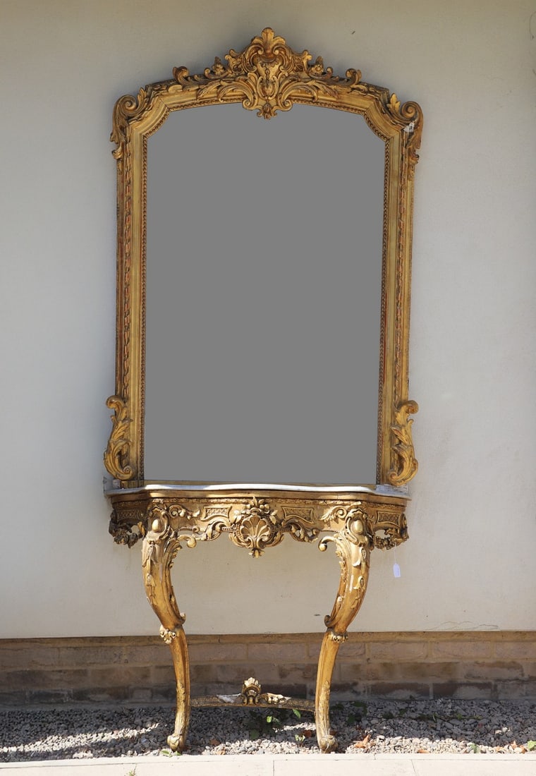 A giltwood console table and mirror,: A giltwood console table and mirror, 19th century, the arch-shaped mirror above a serpentine white marble-topped console table on cabriole supports, the whole embellished with leaf and ‘C’