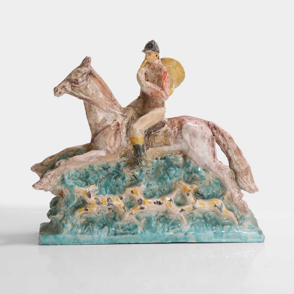 Édouard Cazaux (French, 1889-1974),: Édouard Cazaux (French, 1889-1974), an Art Deco glazed earthenware figure, c.1930s, depicting a hunter on horseback with a pack of dogs, signed, 31cm wide 8.5cm deep 28.5cm high