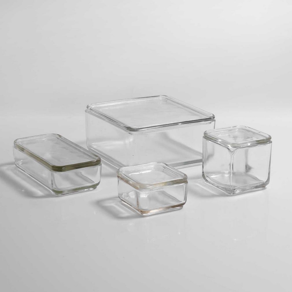 Wilhelm Wagenfeld (German, 1900-1990),: Wilhelm Wagenfeld (German, 1900-1990), a group of four 'Kubus' moulded glass kitchenware, originally designed c.1938, German, manufactured by Vereinigte Lausitzer Glaswerke, largest 18cm wide 18cm dee