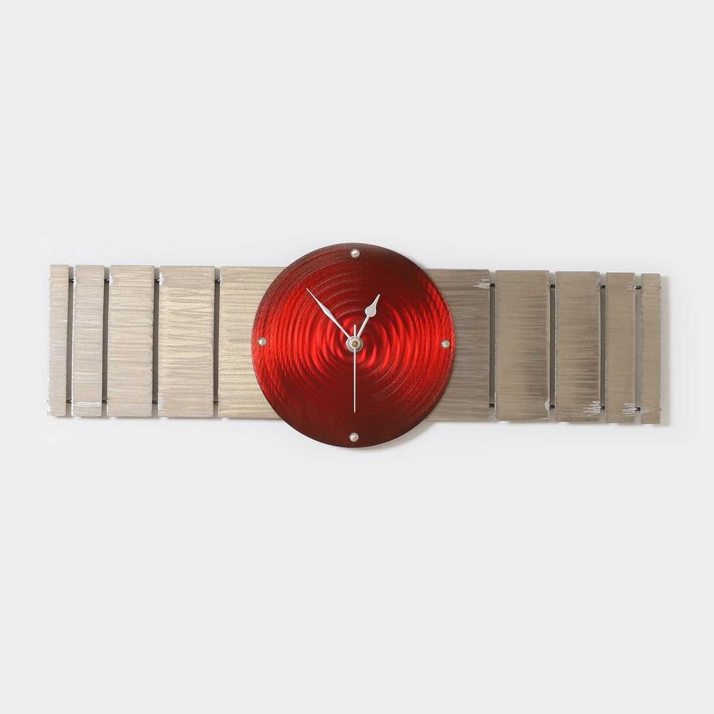 ▲ Jake Howard (b.1969),: ▲ Jake Howard (b.1969), a metal wall clock, the red face over a slatted back, 21 x 54cm Condition Report: This item is not tested and the movement does not function. Otherwise appearing in good