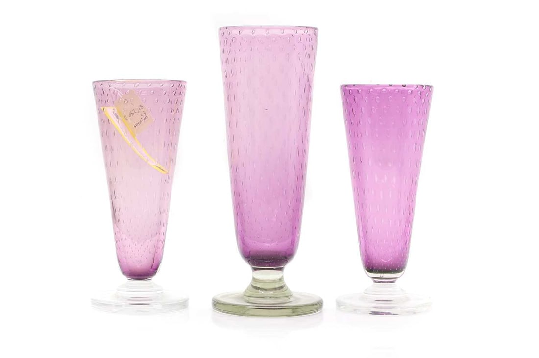 A set of three Stevens & Williams glass vases,: A set of three Stevens & Williams glass vases, c.1940, designed by Keith Murray, each amethyst, with bubble inclusions, 30cm, 30.5cm and 37.5cm high (3) Condition Report Some signs of wear. No signat