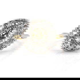 An Edwardian diamond cluster ring,: An Edwardian diamond cluster ring, set to the centre with an old mine cut diamond, light yellow in colour, within a surround of old cut diamonds, one round brilliant replacement, bead set in white on