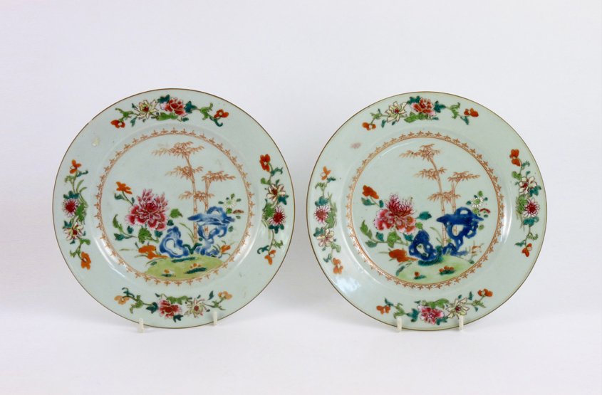 A pair of famille rose Plates, mid 18th century, each p: A pair of famille rose Plates, mid 18th century, each painted with rocks, peony and other flowers within a spearhead border, the rim with trails of flowers, one with frit, 23cm (2)