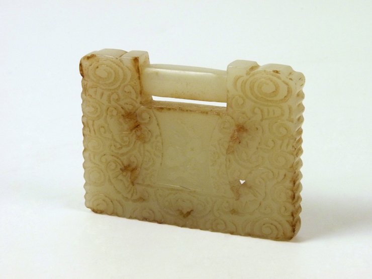 A jade Buckle, 20th century, of rectangular form, carve: A jade Buckle, 20th century, of rectangular form, carved on both sides with clouds, bats and panels of peaches or good luck characters, 7cm