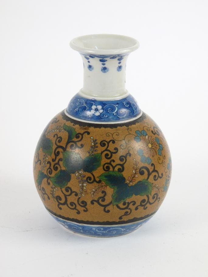 A Yokahama vase, c.1870, with cloisonné flowers and lea: A Yokahama vase, c.1870, with cloisonné flowers and leaves and underglaze blue borders, red mark, 18cm