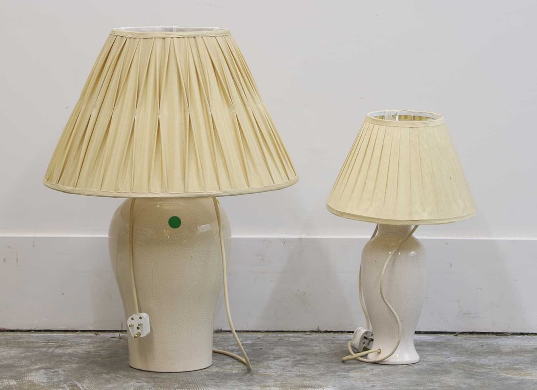 A near pair of cream glazed porcelain lamps,: A near pair of cream glazed porcelain lamps, 20th century, of bulbous form with a crackled effect to the glaze, the largest 25cm wide 45cm high (2) Condition Report We canno