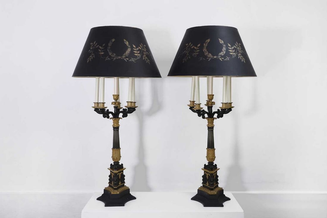 A pair of large Empire-style gilt and patinated bronze candelabras,: A pair of large Empire-style gilt and patinated bronze candelabras, c.1900, each reeded Corinthian column issuing six cast sconces, raised on a tripartite base cast with griffin monopodia, with a tape