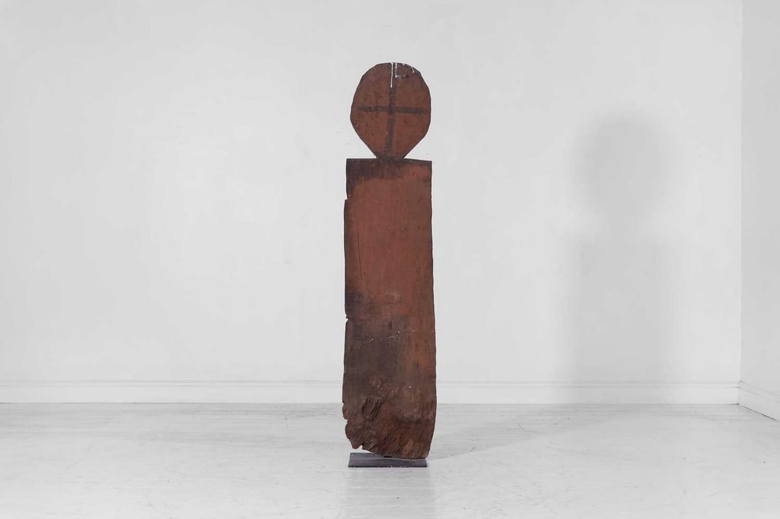 A Gurage carved wooden room divider,: A Gurage carved wooden room divider, 20th century, Ethiopian, of stylised figural form, with traces of red pigment, raised on a metal stand, 39cm wide 30cm deep 156cm high Condition Report: General di