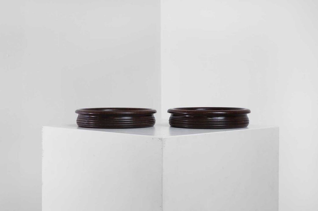 A pair of Regency-style mahogany bottle coasters,: A pair of Regency-style mahogany bottle coasters, late 19th/early 20th century, each with an everted rim and turned decoration, 17cm diameter 3.5cm high (2) Provenance: An East Anglian Private Collect