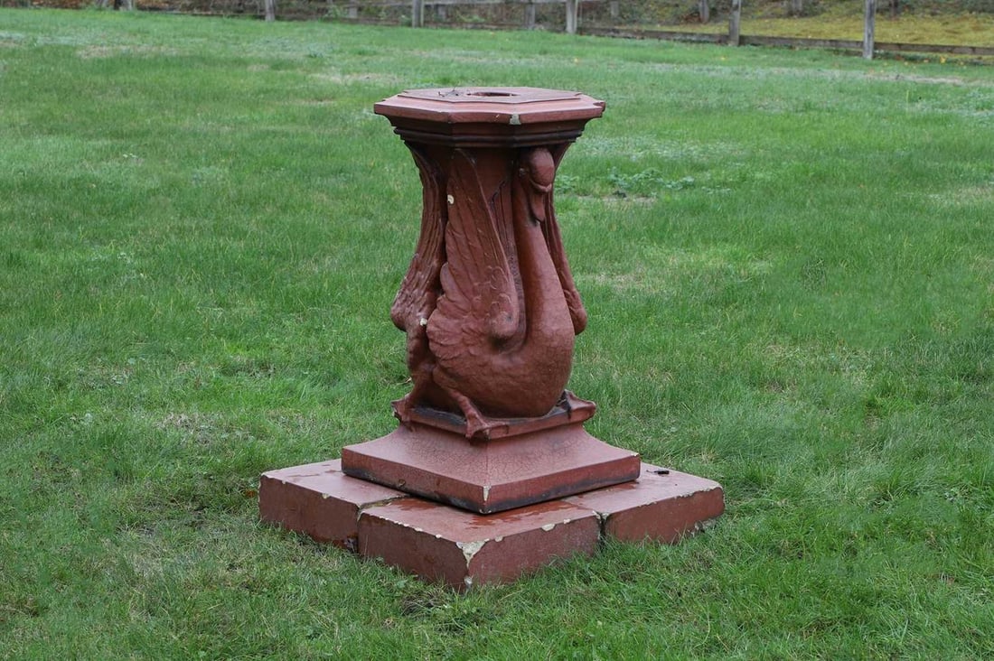 A glazed terracotta sundial pedestal,: A glazed terracotta sundial pedestal, late 19th century, probably by Doulton, Lambeth, the column modelled as a pair of swans, below a cavetto moulded top with concave corners, raised on four square p
