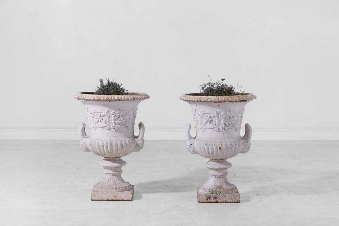 A pair of painted cast iron campana garden urns,: A pair of painted cast iron campana garden urns, second half of the 19th century, each decorated with flowers and foliate scrolls, with twin handles and a fluted square base, 44cm diameter 63cm high (