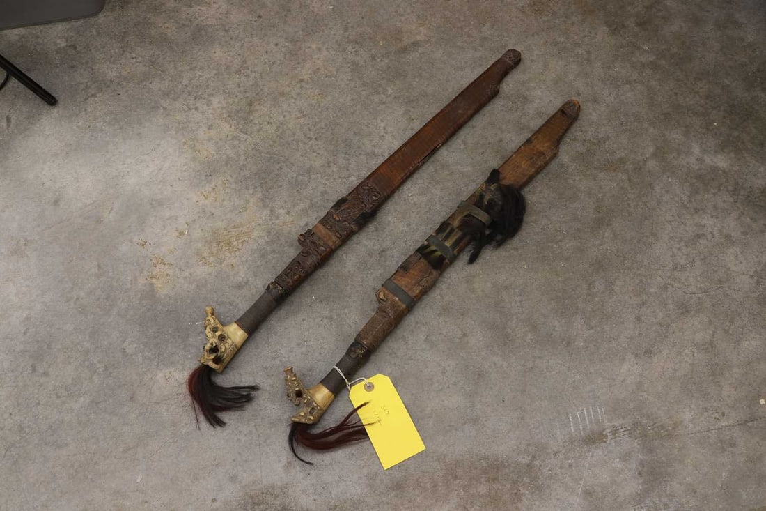 Two Borneo Dayak Mandu or Parang Ilang swords,: Two Borneo Dayak Mandu or Parang Ilang swords, probably early 20th century, the blades each with pierced and chased decoration, thread bound carved bone hilt, with dyed animal fur/hair adornment, car