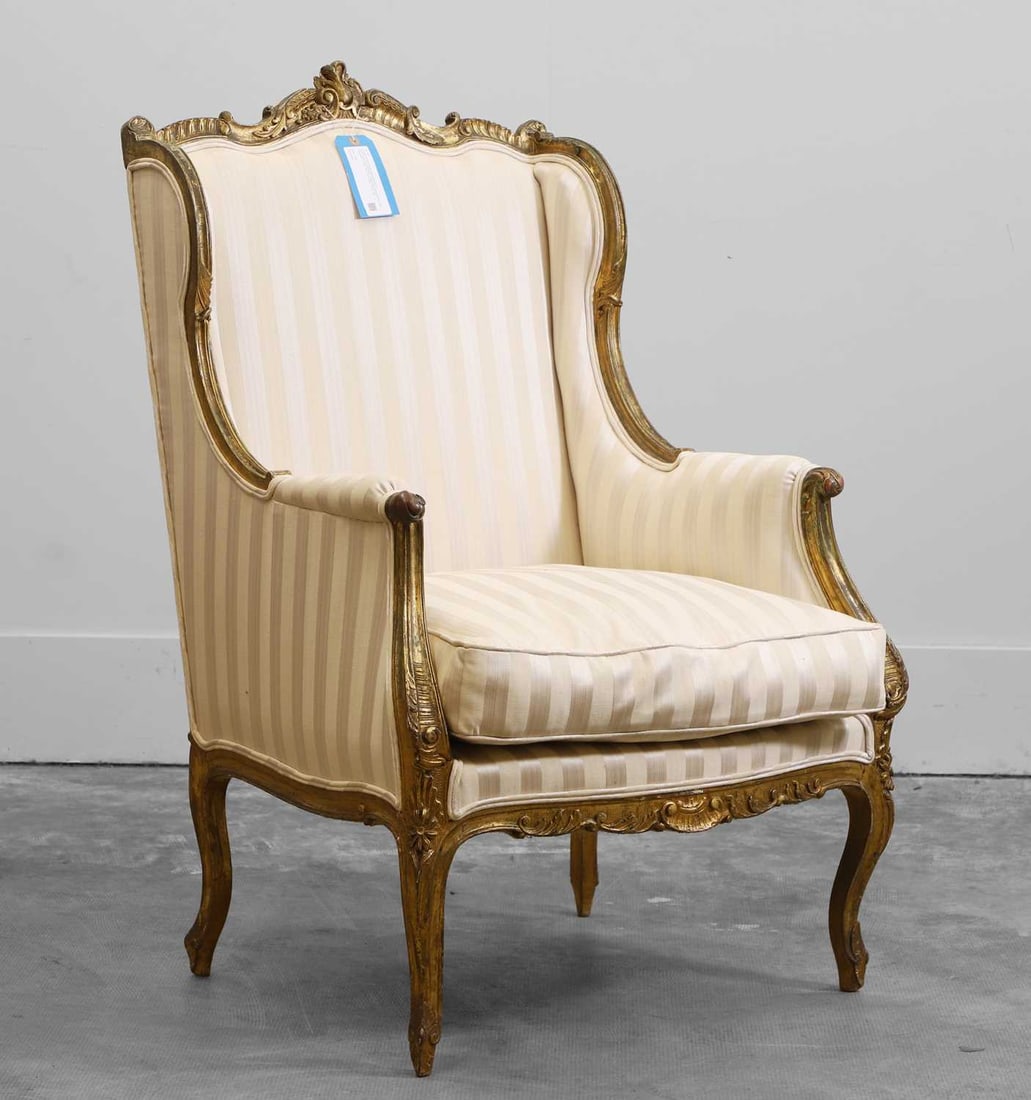 A Louis XV style carved giltwood armchair, (1 of 2)