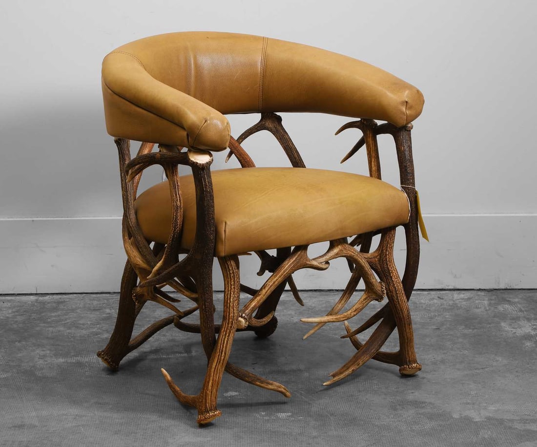 An antler and leather armchair Of recent manufacture: An antler and leather armchair Of recent manufacture Curved and stitched backrest in clubchair style 63cm wide, 63cm deep, 78cm high Condition Report: Structurally stable. Stable and without a rock on