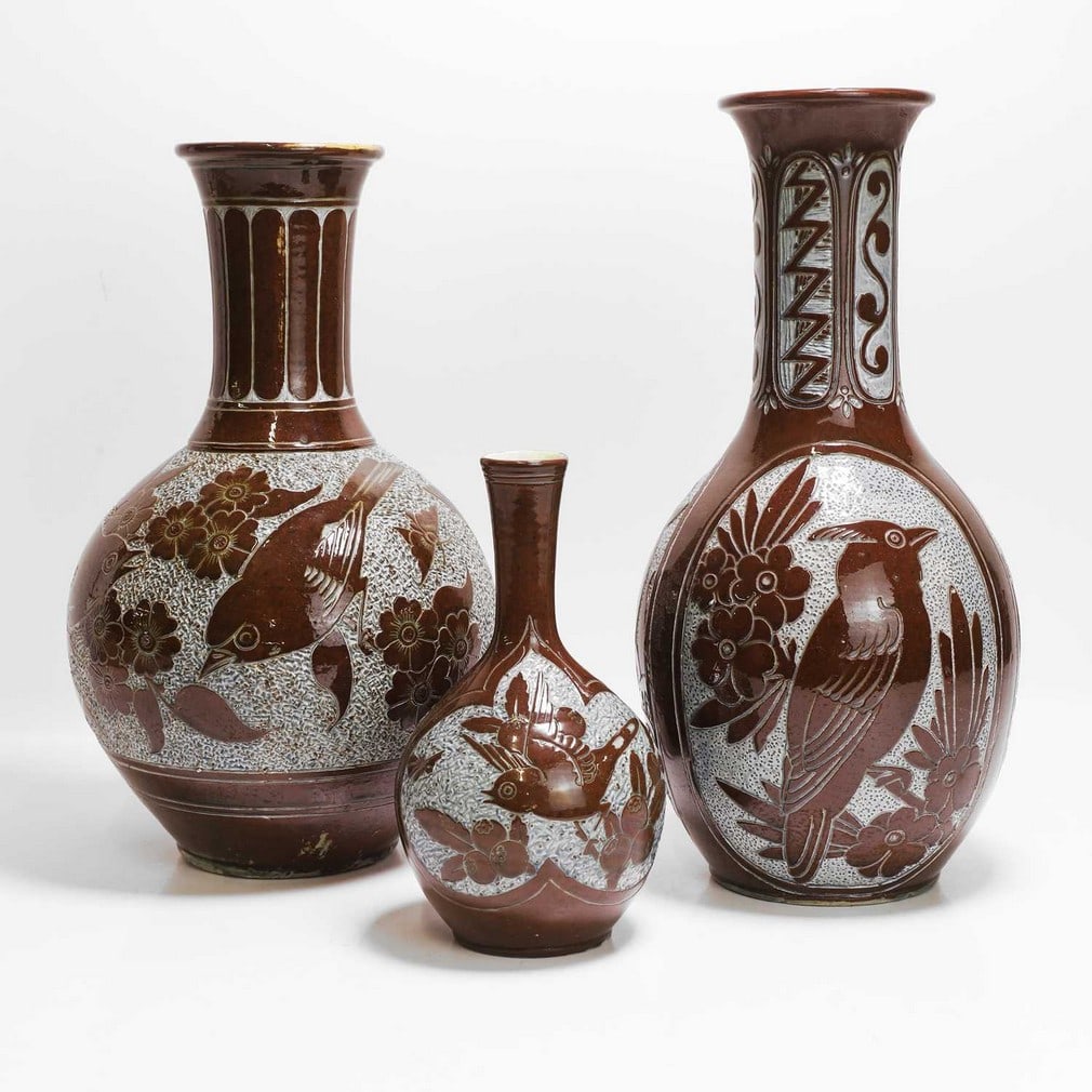 C H Brannam Pottery Three pottery vases: C H Brannam Pottery Three pottery vases 1885-1886-1887, by William Baron, each slip glazed and incised with either birds or fish on a rusticated ground, incised 'CH Brannam Barum, two with artist's mo