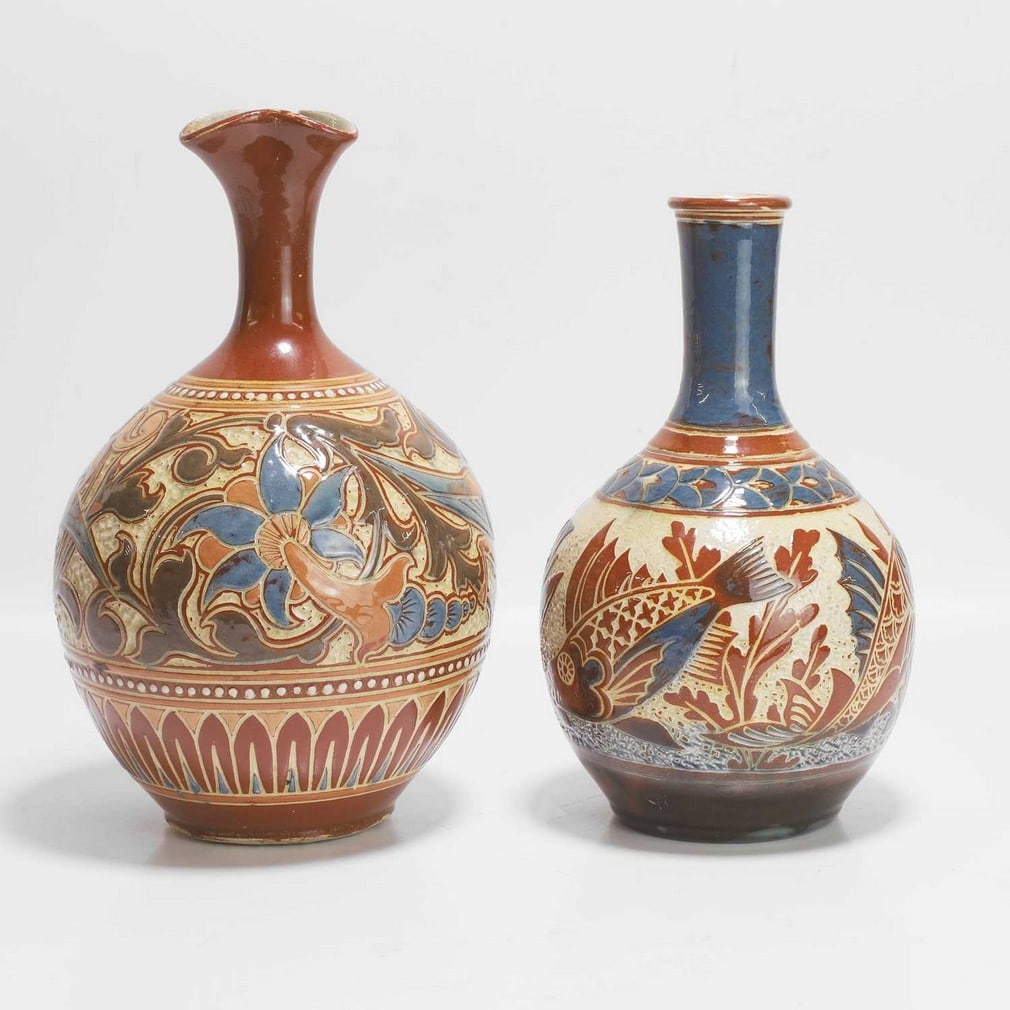 C H Brannam Pottery Two vases: C H Brannam Pottery Two vases Comprising a vase, dated 1886, probably by James Dewdney, of bottle form, with a slip glaze, in brown and blue, a band of birds, with a pinched rim, incised 'CH Brannam B