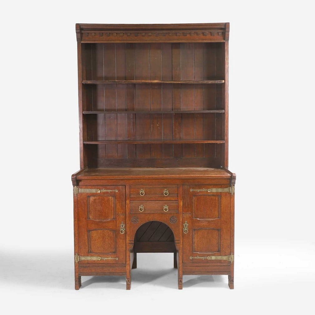Charles Locke Eastlake (1836-1906) An oak dresser: Charles Locke Eastlake (1836-1906) An oak dresser c.1870-1875, with a moulded top, over three adjustable shelves, the lower section centred with an arched well and two drawers, flanked with panelled c