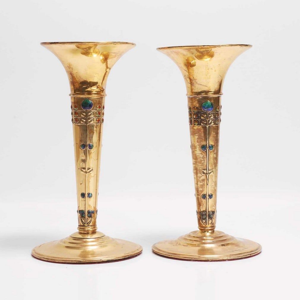 Archibald Knox (1864-1933) for Liberty & Co. A pair of 'Cymric' silver and enamel vases: Archibald Knox (1864-1933) for Liberty & Co. A pair of 'Cymric' silver and enamel vases Birmingham, 1906 and 1907, later gilded, each of tapering trumpet form raised on a circular base, stamped with r