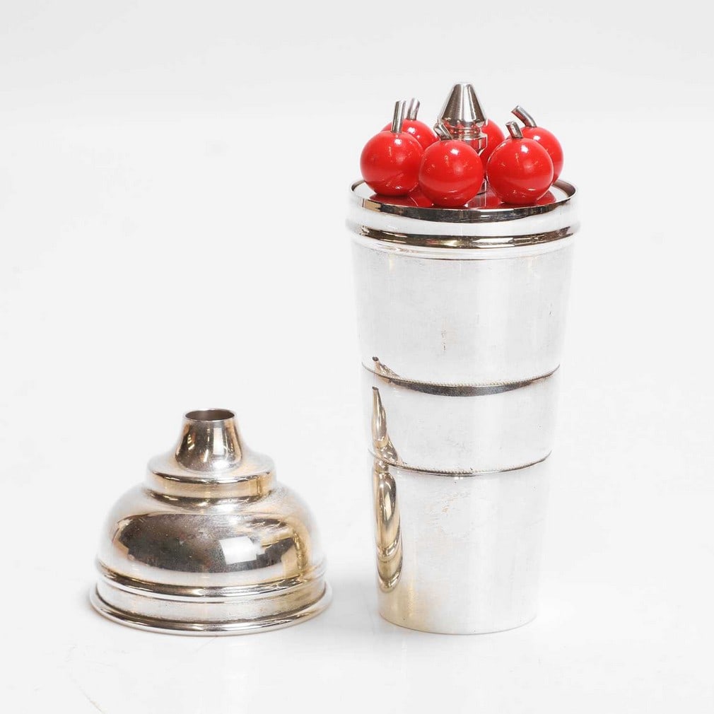 PH Vogel & Co. A 'Cherry' cocktail set: PH Vogel & Co. A 'Cherry' cocktail set Art Deco, chrome and Bakelite, c.1950, comprising six cocktail sticks and a cocktail shaker and measure, stamped marks (11.5cm high) Condition Report: Good